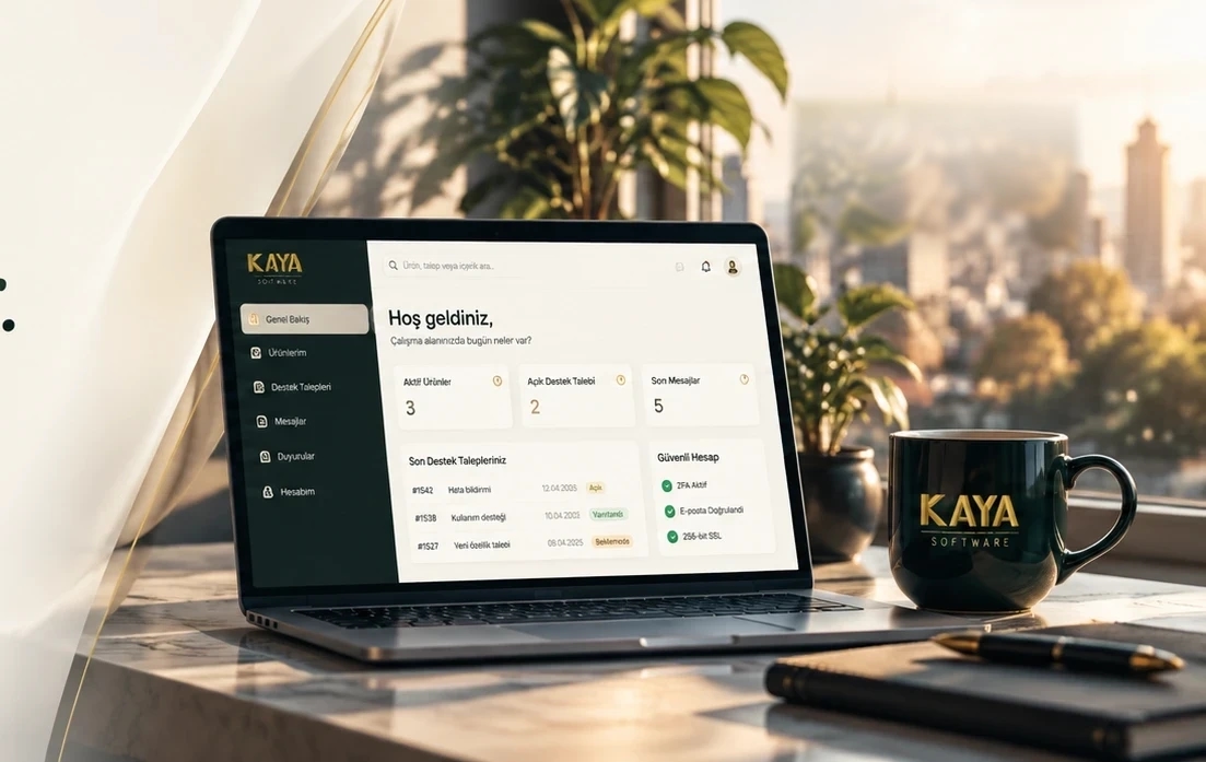 Kaya Software müşteri portalını gösteren dizüstü bilgisayar, çalışma masasında bitki ve kupa.